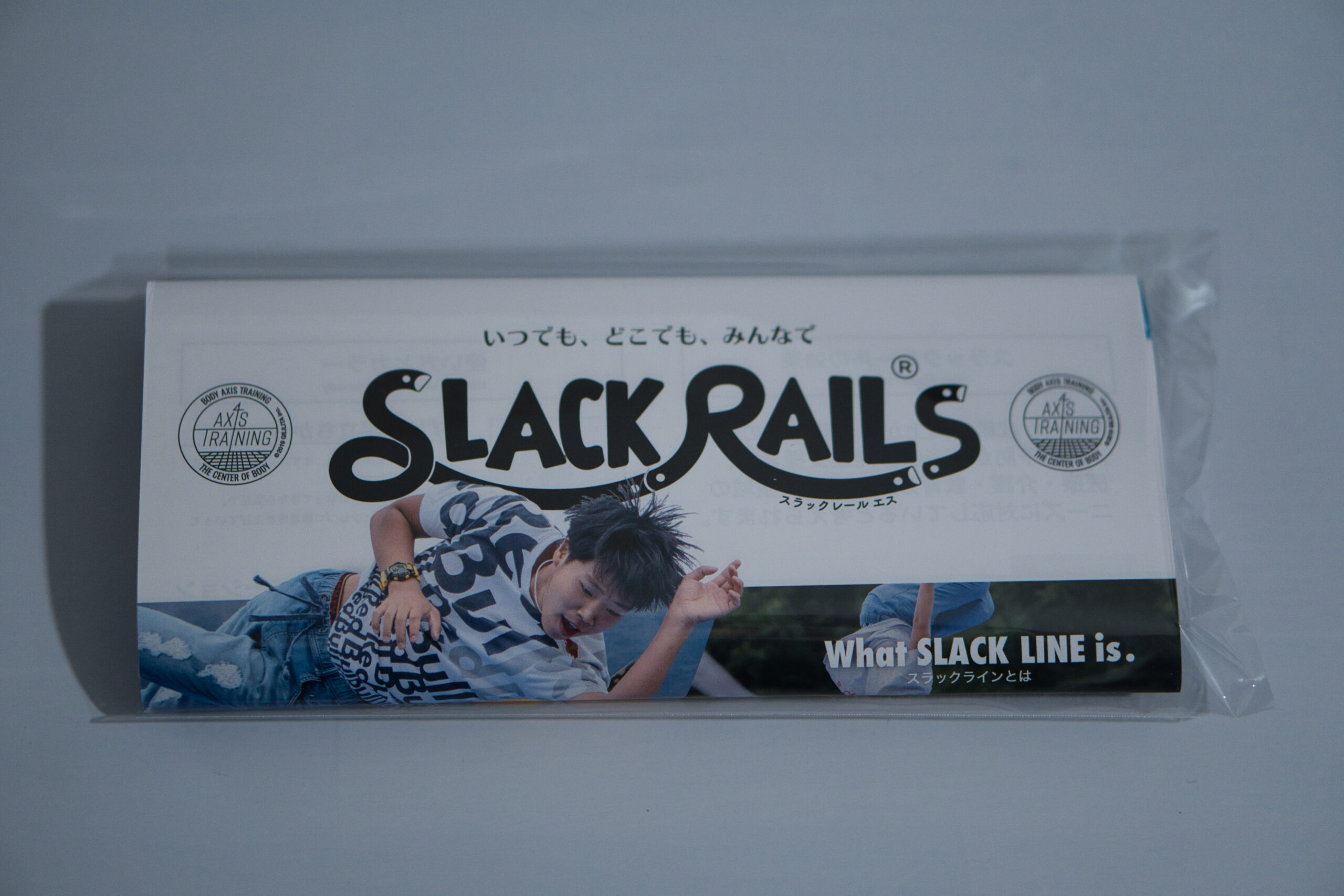 スラックレール エスのパッケージ表面。「いつでも、どこでも、みんなで」のキャッチコピーと BODY AXIS TRAINING ロゴ