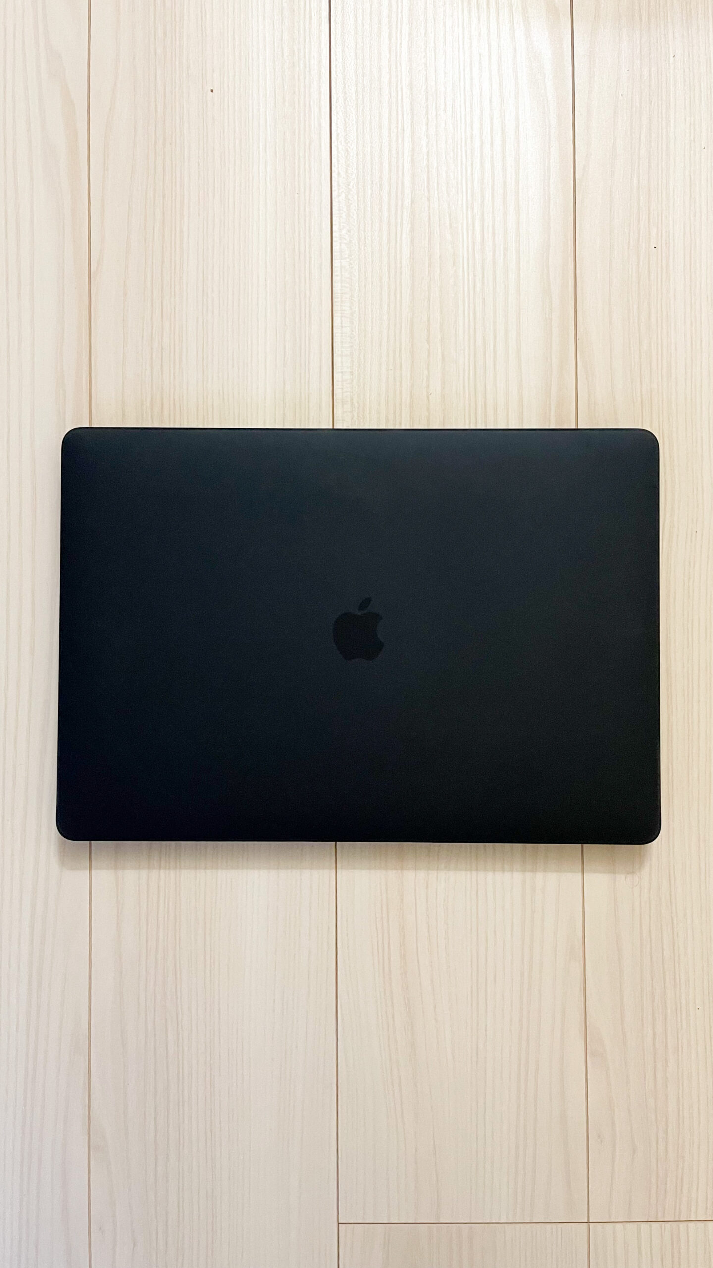 MacBook Pro 15インチ にハードシェルケース（黒）を装着した天面とAppleロゴ