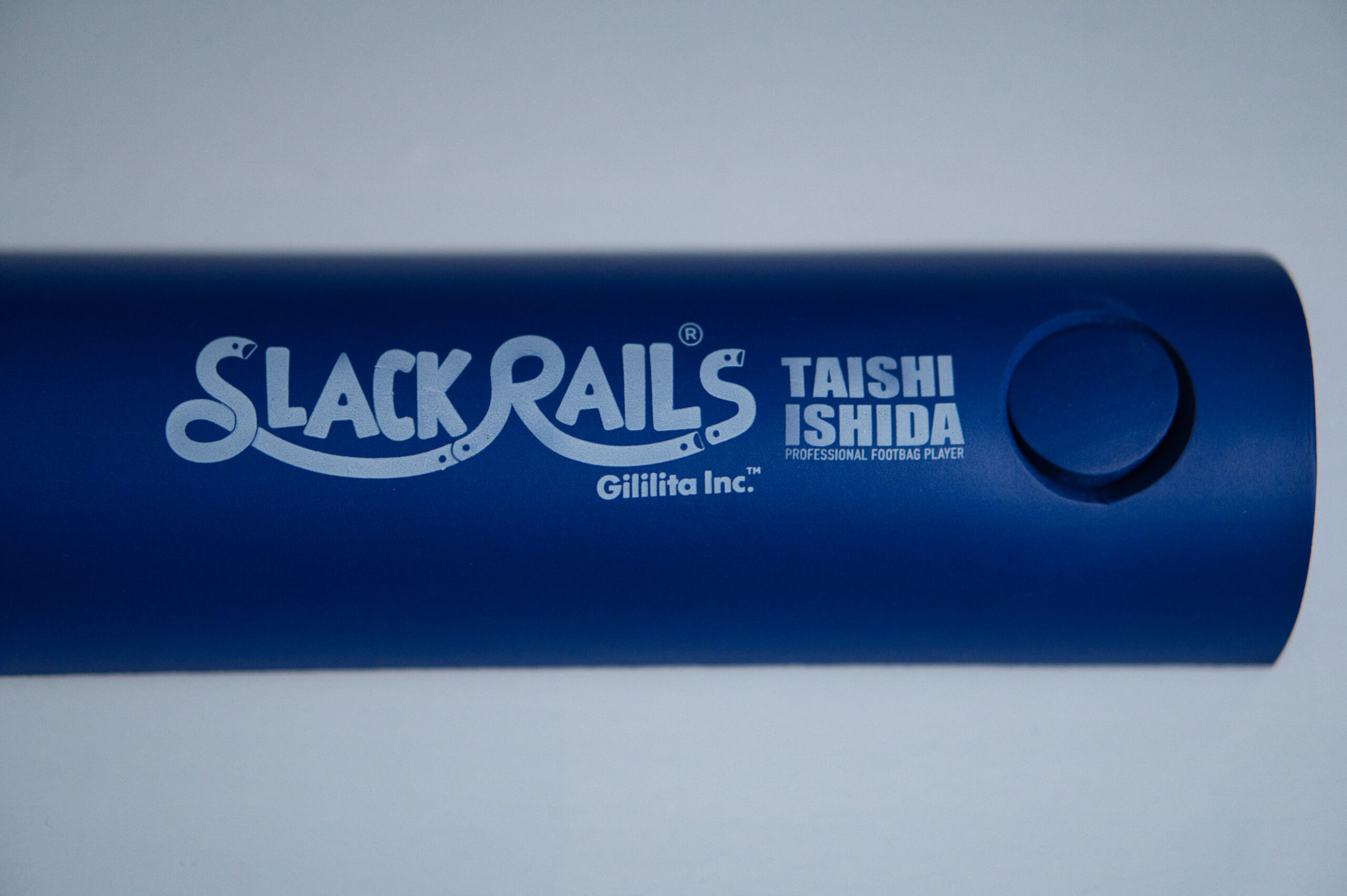 スラックレール エス 本体の刻印クローズアップ。「SLACK RAILS / TAISHI ISHIDA / PROFESSIONAL FOOTBAG PLAYER / Gililita Inc.」の文字と端部のジョイント穴