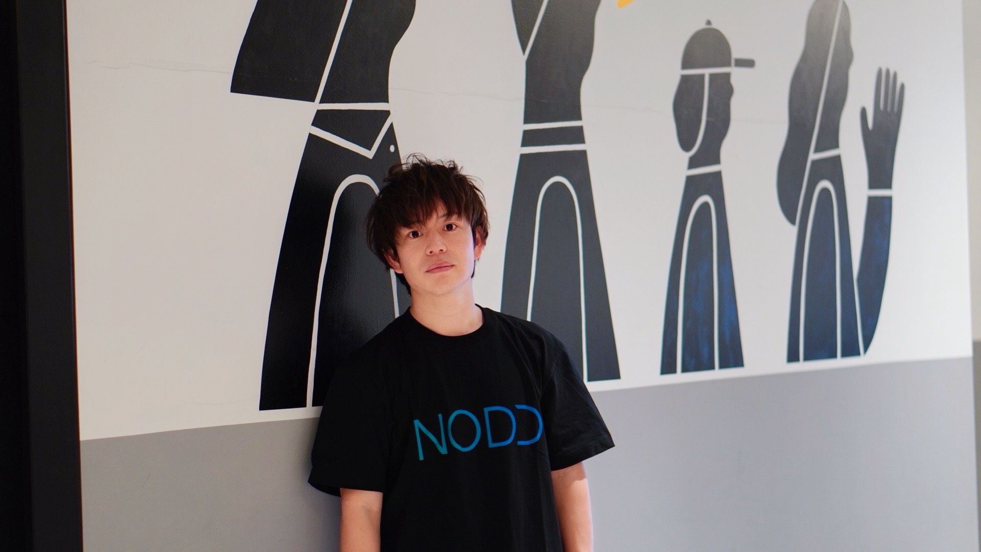 NODDアパレルを着てアートを見上げる石田太志
