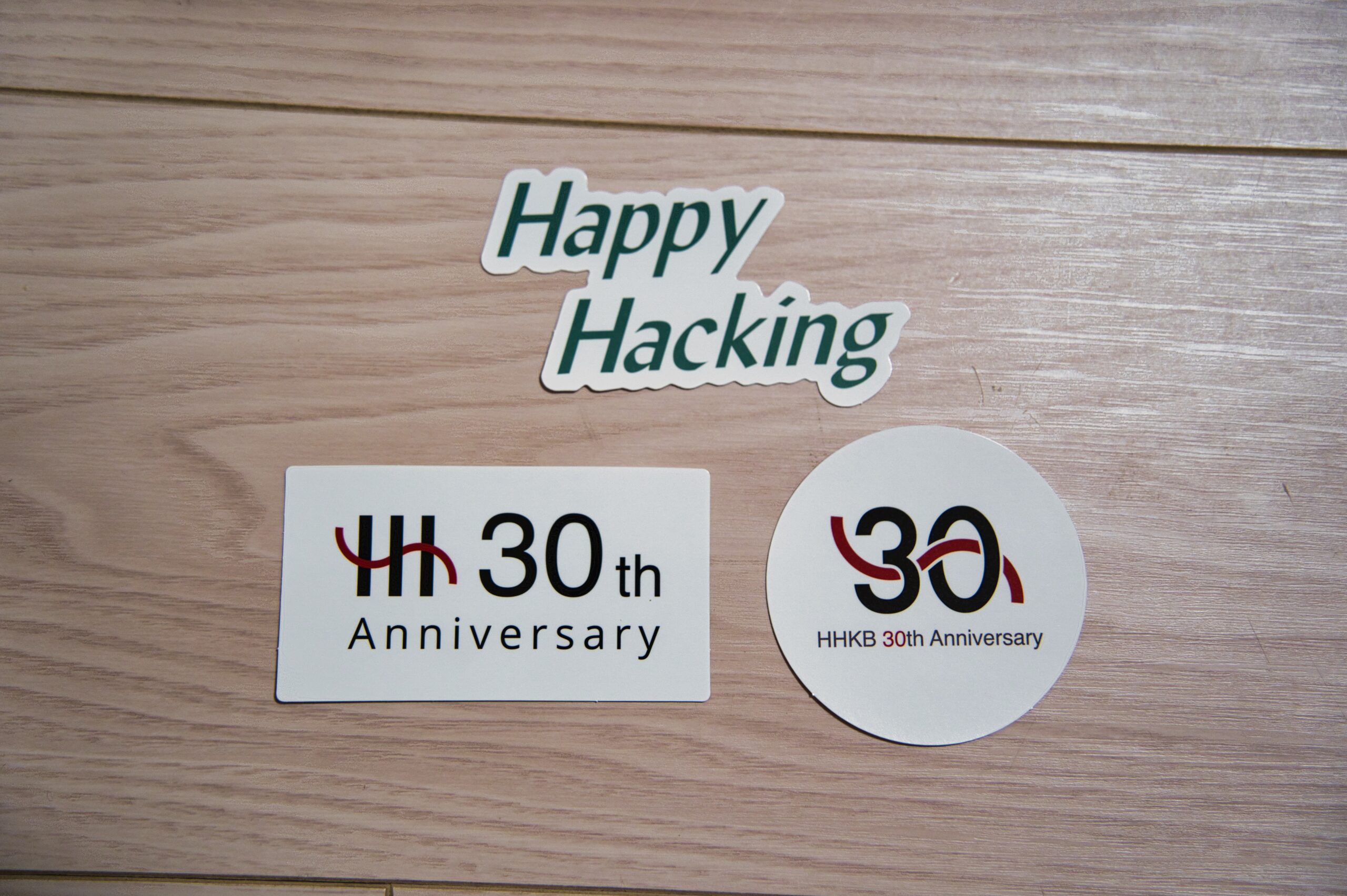 同梱されているHHKB 30周年記念ステッカー3種、Happy Hackingロゴと30thアニバーサリーのデザイン